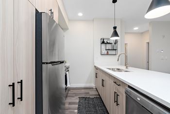 a renovated kitchen with white countertops and stainless steel appliances